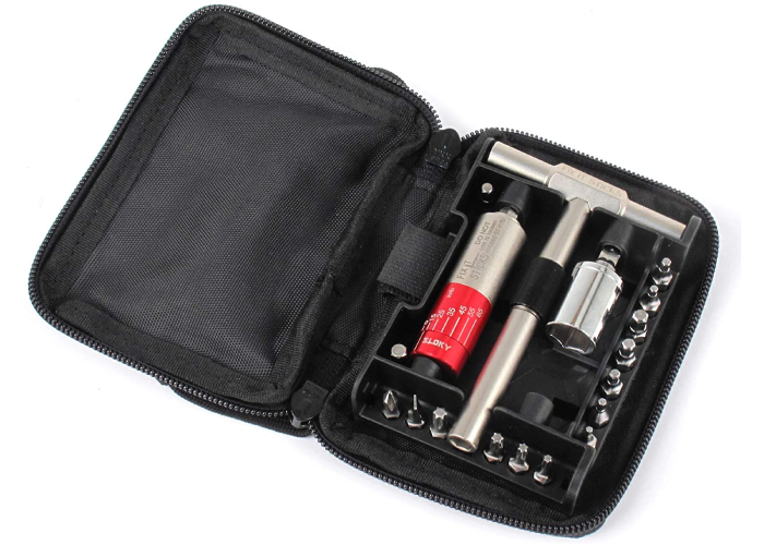 zippered black fabric tool case open to show a torque stick, two sockets, and an assortment of screws