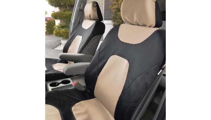  Two-tone cream and black car covers are shown on the two front seats of a car, which has one door open. The seat covers do not cover the arm rests.