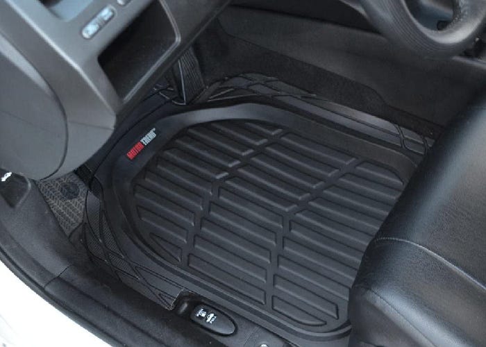 A black car mat over the floor of the driver's seat.