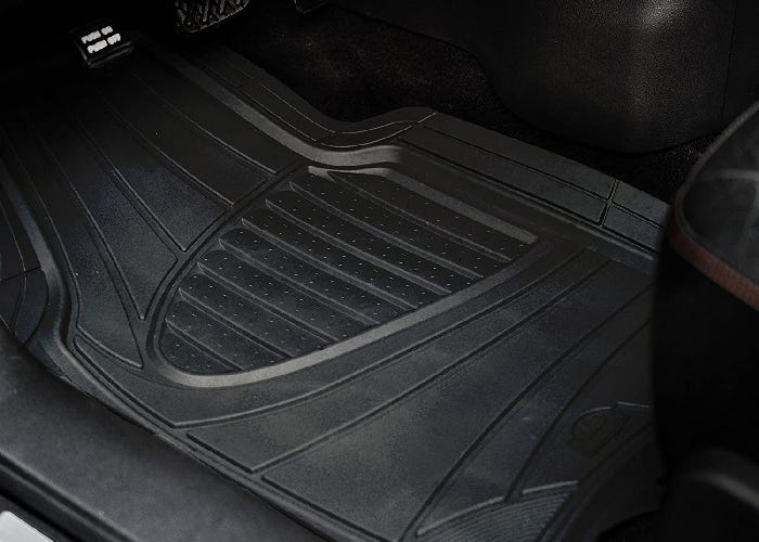 A rubber car mat over the floor of the driver's seat.