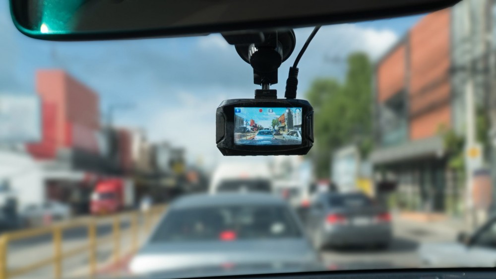 A dash camera that's attached to the rearview mirror records the cars in front of it.